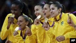 Members of the Brazil women's volleyball team show off their gold medals following a 3-1 win over the United States during the women's gold medal volleyball match at the 2012 Summer Olympics, Saturday, Aug. 11, 2012, in London.