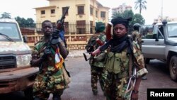 Fighters for the Seleka rebel alliance stand guard in front of the presidential palace in Bangui, Central African Republic, March 25, 2013.