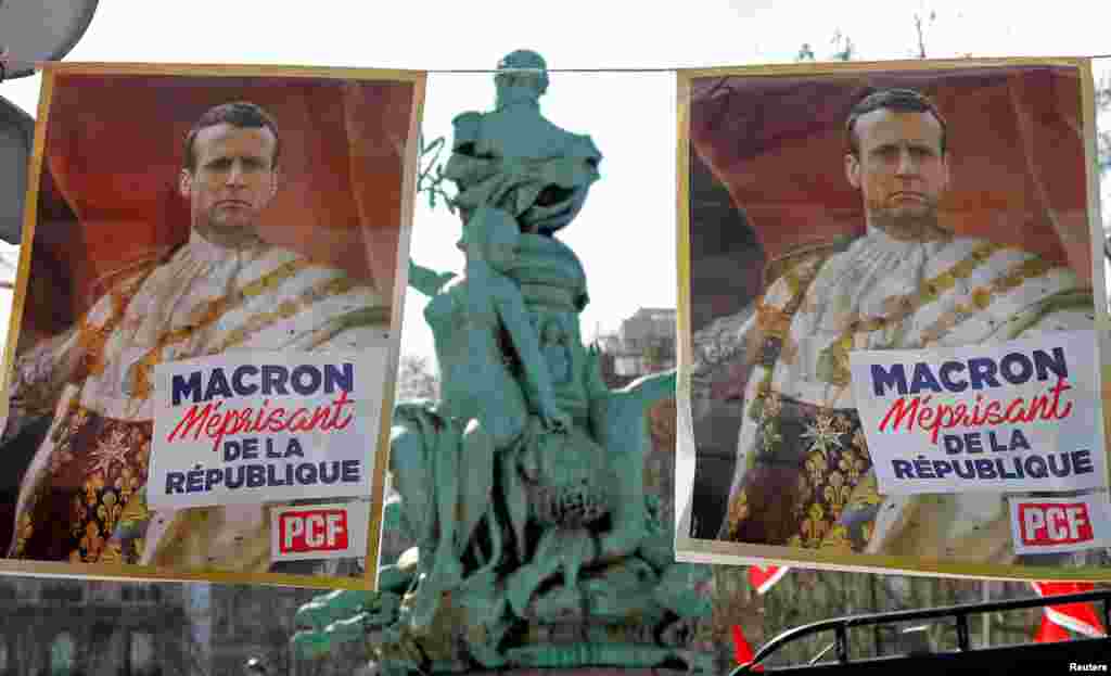 Posters with drawings of French President Emmanuel Macron wearing the coronation tunic of King Louis XVI are displayed during a demonstration by labor unions against the government's reforms, in Paris.