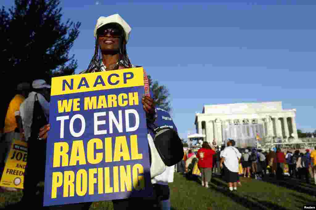 Seorang peserta pawai membawa poster bertuliskan desakan mengakhiri diskriminasi ras pada peringatan 50 tahun Pawai Washington 1963 di Lincoln Memorial di Washington (24/8). (Reuters/Kevin Lamarque)