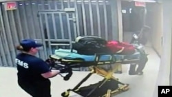 Gambar dari video CCTV pusat penahanan Waller County tanggal 13 Juli memperlihatkan petugas membawa tandu ke arah sel tempat Sandra Bland ditahan, di Hempstead, Texas.