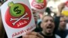 Egyptian protesters hold placards with the Arabic inscription reading ‘danger’ and shout slogans as they demonstrate against the International Monetary Fund (IMF) delegation visit, in front of the General-Prosecutor's office in Cairo, April 3, 2013. 