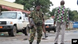 A Burundian soldier with his gun and rocket launcher guard a deserted street in Bujumbura, Burundi, Nov. 8, 2015.