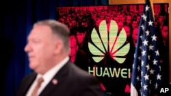 A monitor displays the logo for "Huawei" behind Secretary of State Mike Pompeo as he speaks during a news conference at the State Department in Washington, Wednesday, July 15, 2020. (AP Photo/Andrew Harnik, Pool)