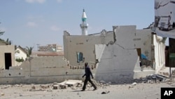 Seorang pria berjalan di dekat bangunan yang hancur akibat ledakan di Mogadishu, Somalia, 22 Desember 2018.
