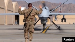 A U.S. airman guides a U.S. Air Force MQ-9 Reaper drone as it taxis to the runway at Kandahar Airfield, Afghanistan, March 9, 2016. 