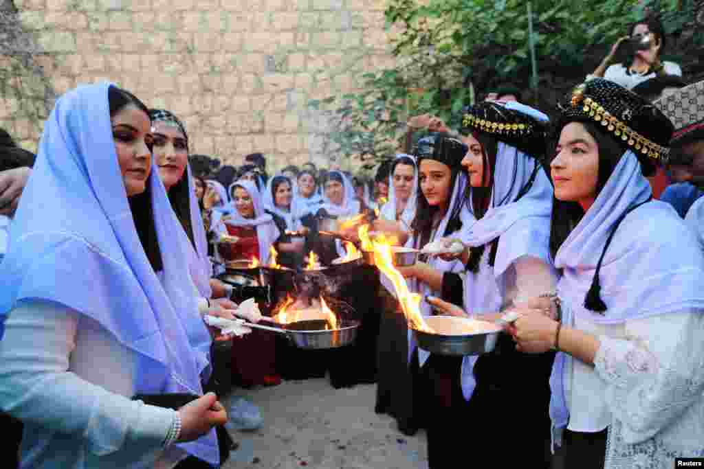 ក្រុមជនជាតិភាគតិច Yazidi អុជទៀនអំឡុងពិធីមួយដើម្បីអបអរពិធីចូលឆ្នាំ Yazidi នៅព្រះវិហារ Lalish ក្នុងទីក្រុង Shikhan ក្នុងខេត្ត Dohuk ប្រទេសអ៊ីរ៉ាក់កាលពីថ្ងៃទី១៧ មេសា ២០១៨។