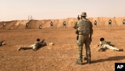 FILE - Members of the Maghawir al-Thawra Syrian opposition group receive firearms training from U.S. Army Special Forces soldiers at the Al-Tanf military outpost in southern Syria on Oct. 22, 2018.