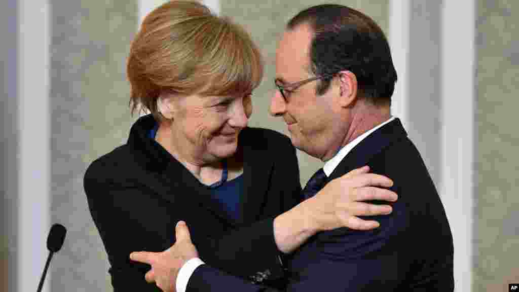 French President Francois Hollande, right, and German Chancellor Angela Merkel hug each other after their marathon talks in Minsk, Belarus, Feb. 12, 2015.