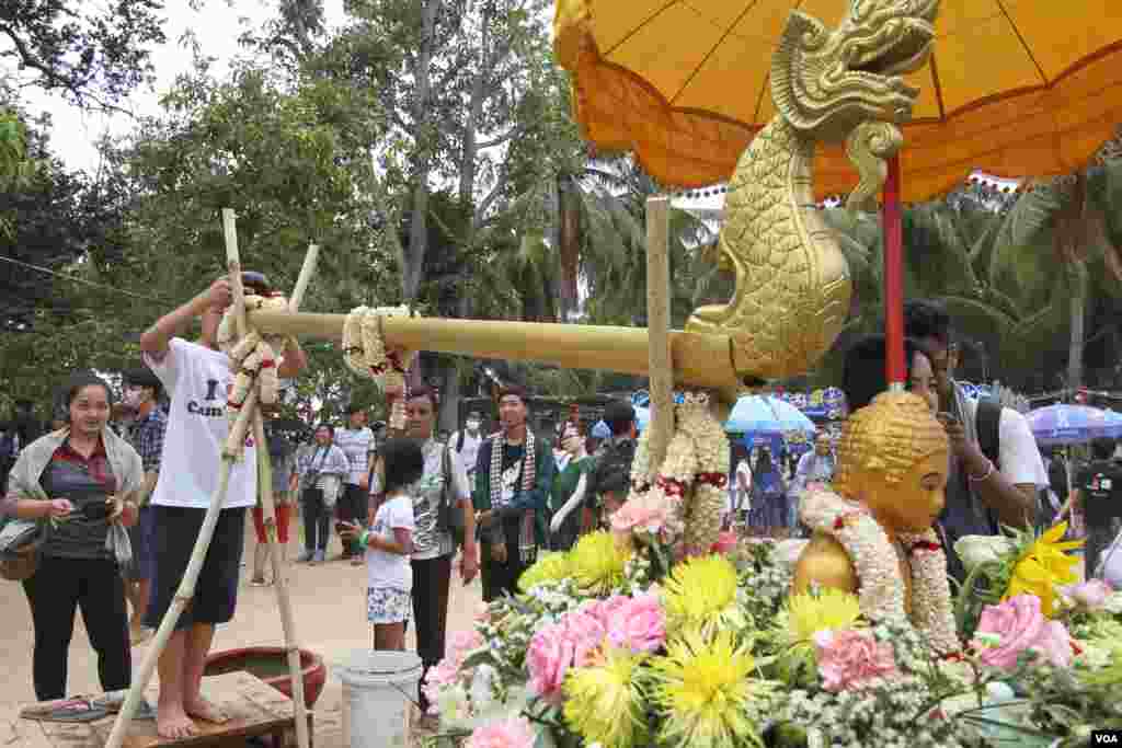 ក្មេងប្រុសម្នាក់ស្រោចទឹកលើពុទ្ធបដិមាមួយក្នុងពិធីមួយមុនចូលឆ្នាំខ្មែរនៅវត្តជ្រោយអំពិលខ័ណ្ឌច្បារអំពៅរាជធានីភ្នំពេញកាលពីថ្ងៃសៅរ៍ទី០៩ ខែមេសានេះ។ ប្រជាជនខ្មែរប្រារព្ធពិធីបុណ្យចូលឆ្នាំខ្មែរចាប់ពីថ្ងៃទី ១៣ដល់ទី១៦ខែមេសាឆ្នាំ២០១៦នេះ នៃឆ្នាំវក សត្វស្វា។ (ឡេង ឡែន/VOA) 