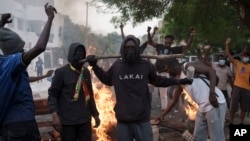 Demonstrators stand next to a barricade set on fire during a protest in support of the main opposition leader Ousmane Sonko in Dakar, Senegal, May 29, 2023.