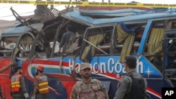 Petugas keamanan Pakistani memeriksa bis yang hancur akibat ledakan bom di Peshawar, Pakistan (16/3)