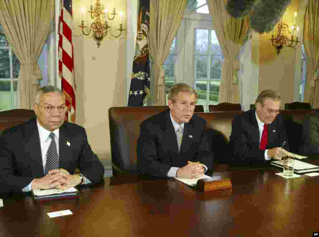 Then President George W. Bush makes a statement to reporters while Secretary of State Colin Powell and Secretary of Defense Donald Rumsfeld look on following a Cabinet meeting, March 20, 2003.