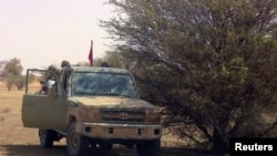 Des combattants du groupe séparatiste rebelle MNLA, à bord d'un véhicule 4x4, s'abritent à l'ombre d'un arbre près de Tabankort, Mali, le 15 février 2015 (Archives) 