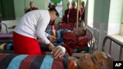 Buddhist monks who suffered burn injuries when security forces cracked down on protesters are treated at a hospital in Monywa town shop, northwestern Burma, Nov. 29, 2012. Security forces used water cannons and other devices to break up the rally hours before opposition leader Aung San Suu Kyi was expected. (AP Photo/Gemunu Amarasinghe)