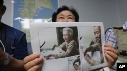 南韓女士申筠順舉著曾境被迫充當日軍慰安婦的92歲母親白奉禮的照片，在首爾的家中接受采訪。(2020年7月29日)