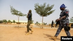 Des policiers marchent à l'école JSS Jangebe, un jour après que plus de 300 écolières ont été enlevées par des bandits, à Zamfara, au Nigeria, le 27 février 2021.
