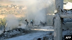 Sirijci koriste zemlju i prašinu da bi ugasili vatru na mjestu navodnog vazdušnog udara uJisr al-Shughu, u provinciji Idlib, 4. septembra 2018.