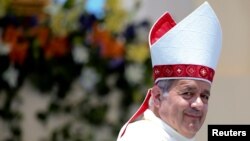 FILE - Bishop Juan Barros looks on as Pope Francis leaves at the end of a mass at the Lobito beach in Iquique, Chile, Jan. 18, 2018. 