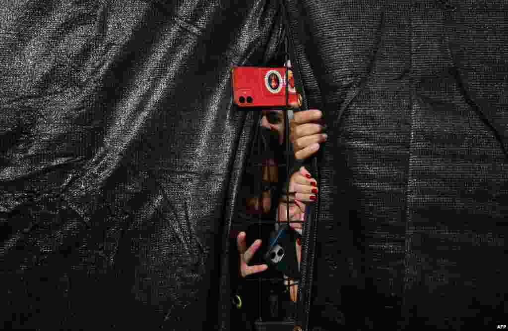 Fans take pictures through a fence during the second practice session for the Las Vegas Formula One Grand Prix in Las Vegas, Nevada, on Nov. 21, 2024.
