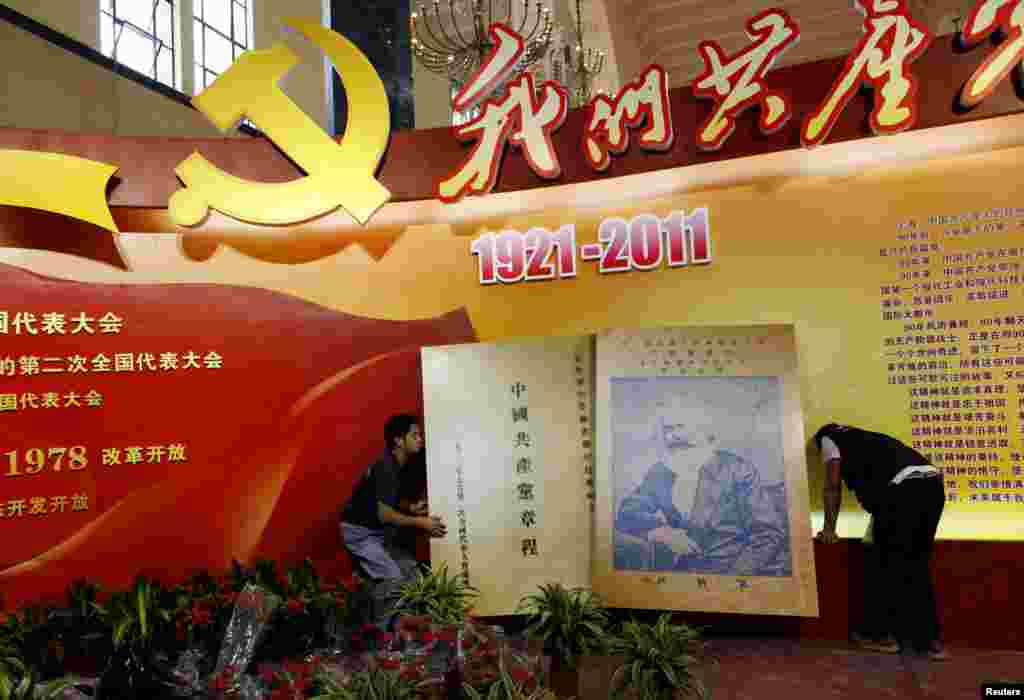 2011年6月14日,在上海展览中心举办的关于中共历史的展览,工人们树立起“中国共产党章程”的牌子,上面有卡尔·马克思的图片。