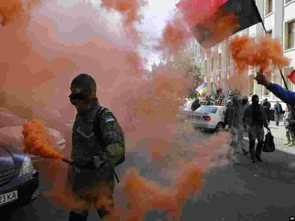 Activists from the Right Sector party ignite flares near the presidential administration building during a rally in Kyiv, Sept. 17, 2014.