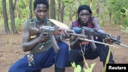 Fighters loyal to the Lord's Resistance Army (LRA) pose with their rifles inside the forest near River Mbou in the Central African Republic (CAR) in this handout picture dated April 4, 2012. 