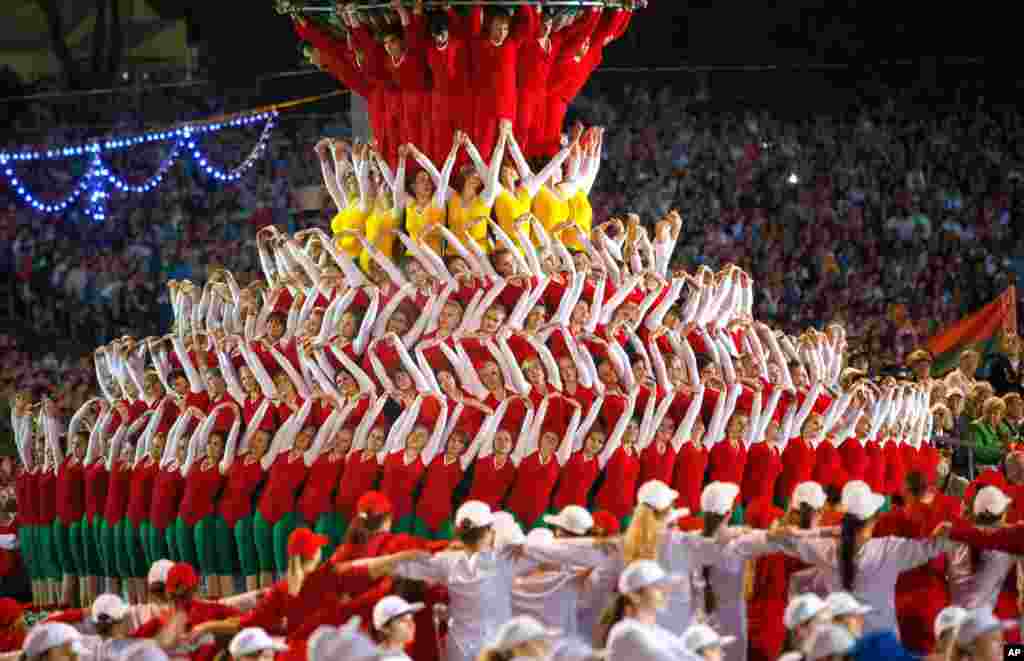 Para atlit Belarusia menampilkan kebolehan mereka dalam sebuah parade yang menandai hari kemerdekaan negara itu di Minsk, Belarus, 3 Juli 2014. 
