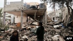 Anak-anak mengamati puing-puing bangunan yang dihancurkan oleh Israel dalam pengeboman di Rafah, Gaza, Sabtu, 27 Januari 2024. (Foto: AFP)