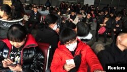 FILE: Passengers wearing masks are seen at the waiting area for a train to Wuhan at the Beijing West Railway Station, ahead of the Chinese Lunar New Year, in Beijing, China January 20, 2020. (REUTERS/Stringer)