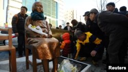 FILE - A statue representing the sexual victims by the Japanese military stands in front of Japanese Consulate in Busan, South Korea, Dec. 30, 2016. A Buddhist monk set himself on fire to protest the agreement with Japan to settle the emotional issue. 