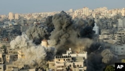 Asap membubung dari ledakan akibat serangan udara Israel dan Mesir ke gedung pusat kebudayaan Said al-Mishal di Kota Gaza, 9 Agustus 2018.
