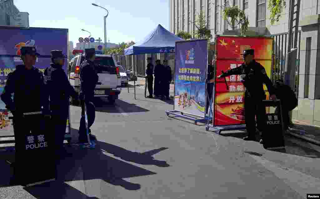 Police admit a vehicle through the checkpoint in Urumqi, Sept. 17, 2014.