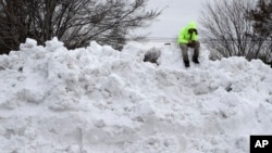 Troy Herrington, sentado sobre una montaña de nieve, espera a su jefe para que lo recoja en Greensboro, Carolina del Norte, luego de limpiar un estacionamiento de un centro comercial.