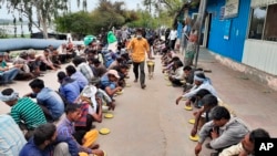 Homeless and impoverished Indians receive food at a government shelter in New Delhi, March 26, 2020. 