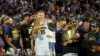 Nikola Jokić i njegova ćerka Ognjena pokazuju prstom na trofej "Bil Rasel", koji je Jokić dobio kao MVP finala plej-ofa (Foto: USA TODAY Sports/Kyle Terada)