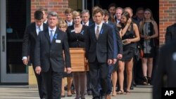 The casket of Otto Warmbier is carried from Wyoming High School after his funeral, June 22, 2017.