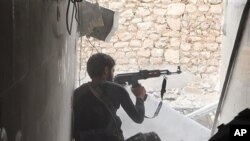 FILE - An Islamic state group fighter in Kobani, FILE - An Islamic State fighter in Kobani, Syria. 