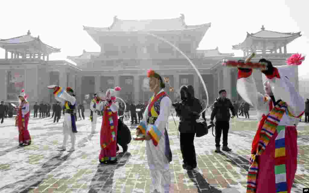 Youths play instruments in front of the Pyongyang Grand Theater to celebrate the rocket launch, Pyongyang, North Korea, December 12, 2012.