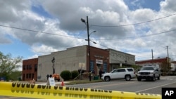 Los investigadores trabajan en el lugar de un tiroteo fatal en el centro de Dadeville, Alabama, el domingo 16 de abril de 2023. Varios murieron durante un tiroteo en una fiesta de cumpleaños el sábado por la noche, dijo la Agencia de Cumplimiento de la Ley de Alabama.