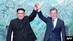 문재인 한국 대통령과 김정은 북한 국무위위원장이 지난 27일 경기도 파주 판문점에서 '판문점 선언문'에 서명, 교환한 뒤 손을 맞잡아 들어올리고 있다. 