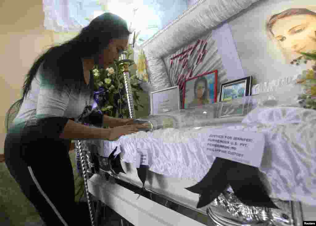 A woman pays her respects to slain transgender, Jennifer Laude, inside a funeral home in Olongapo City, north of Manila, Oct. 21, 2014.