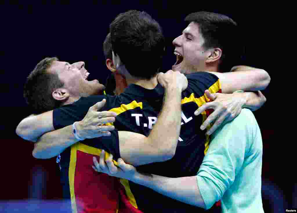 Germany's Dimitrij Ovtcharov (R) celebrates winning with his teammates in the men's table tennis match against Hong Kong.