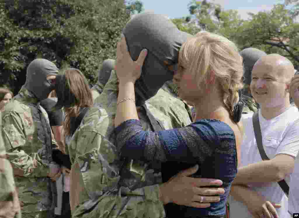 Friends and relatives say goodbye to volunteers before they are sent to the eastern part of Ukraine to join the ranks of a special battalion "Azov," fighting against pro-Russian separatists, in Kyiv, Ukraine, Aug. 17, 2014.