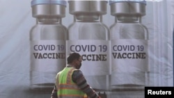 FILE - A ground staff walks past a container kept at the Cargo Terminal 2 of the Indira Gandhi International Airport, which according to the officials will be used as a COVID-19 vaccine handling and distribution center, Dec. 22, 2020.