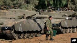 FILE - An Israeli soldier walks past tanks near the Israel and Gaza border, July 10, 2014. The United States and Israel are negotiating a new deal regarding military aid.