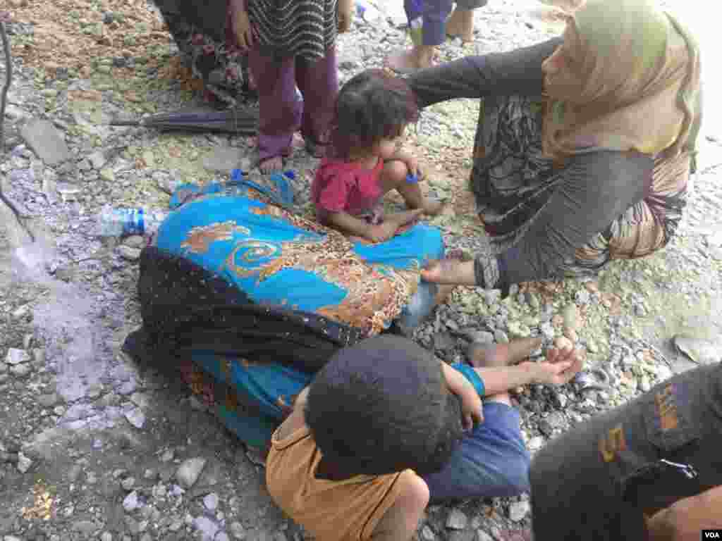 This woman collapses, saying she can walk no further in the 45-degree Celsius heat after months of food and water shortages, in Mosul, Iraq, July, 5, 2017. (H. Murdock/VOA)