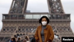 Une femme porte un masque de protection sur l'esplanade du Trocadéro devant la Tour Eiffel à Paris, France, le 1er février 2020. (REUTERS/Gonzalo Fuentes)