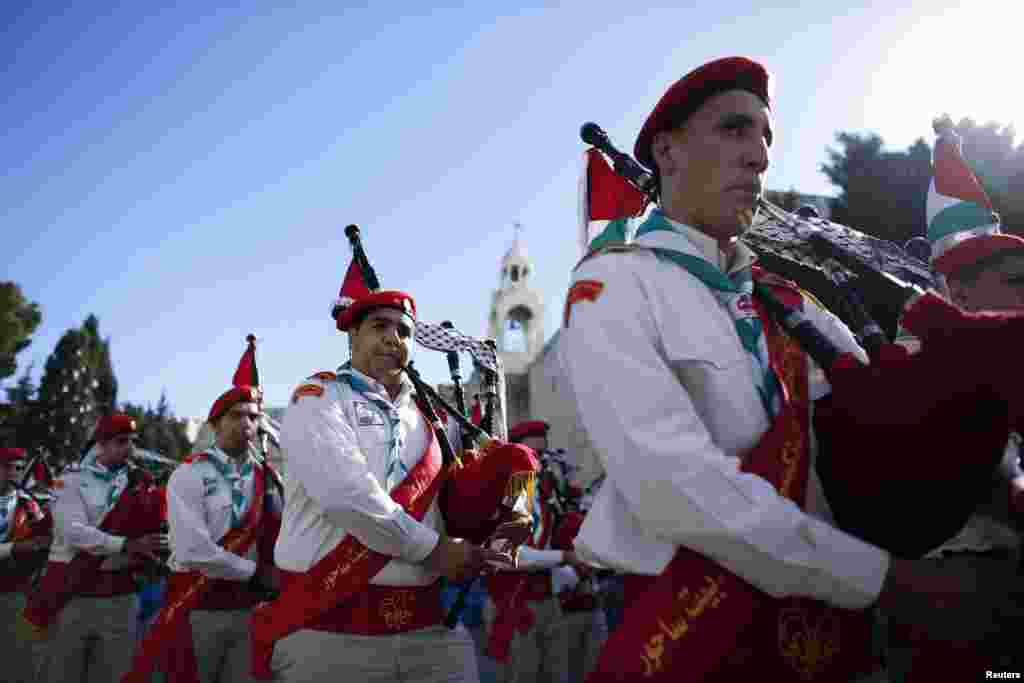 A Palestinian boy scout marching band parades during a Christmas procession at Manger Square in front of the Church of the Nativity, the site revered as the birthplace of Jesus, in the West Bank town of Bethlehem,December 24, 2012.