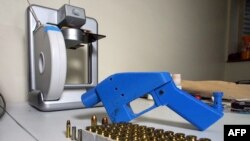 FILE - A Liberator pistol is seen next to the 3-D printer on which its components were made, July 11, 2013. 